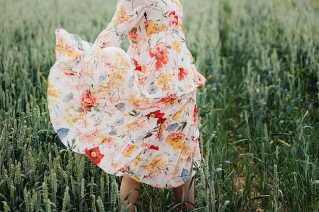 Femme en robe à fleurs marchant dans un jardin