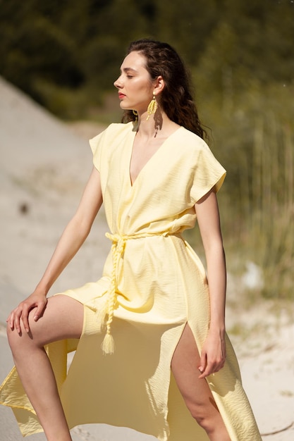 Femme en robe jaune assise sur la plage