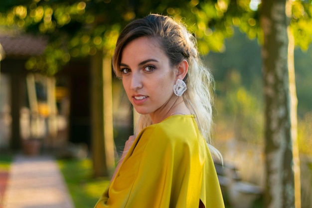 Femme en robe jaune au printemps au coucher du soleil contre le contre-jour