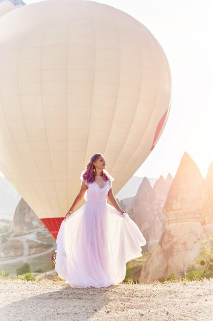 Femme en robe longue sur fond de ballons en Cappadoce