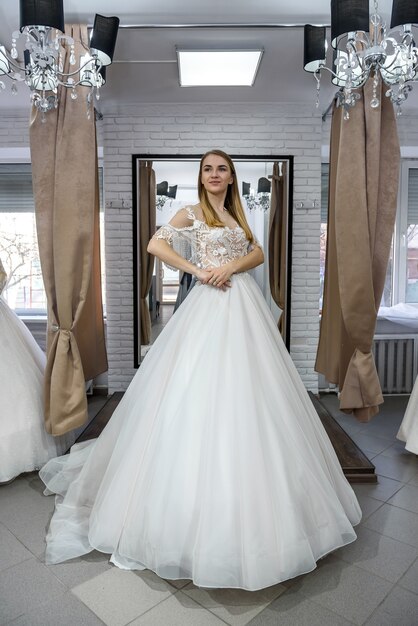 Femme en robe de mariée en pleine longueur en magasin