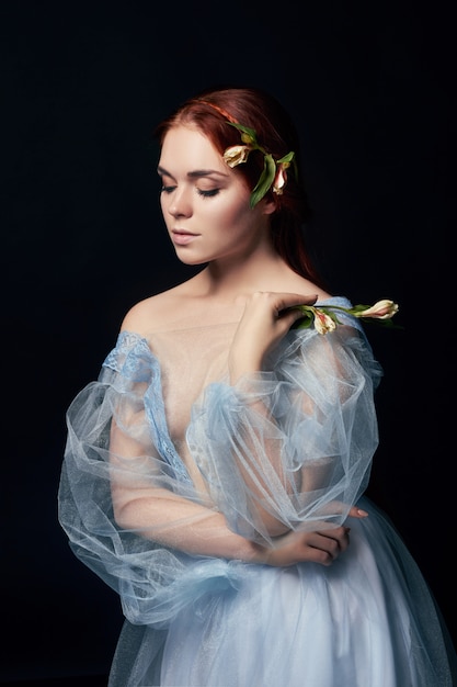 femme avec une robe médiévale et une fleur dans ses mains