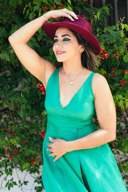 Femme en robe posant à côté du chapeau rouge dans la rue