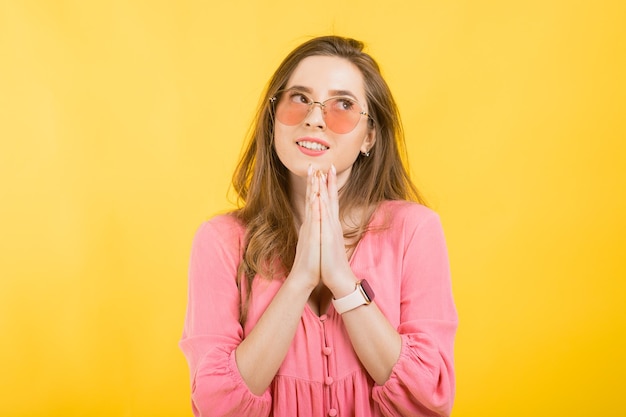 Femme en robe rose sur fond jaune