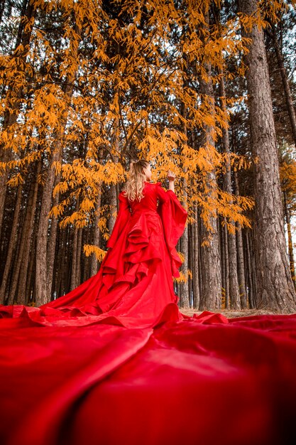 Une femme en robe rouge dans une forêt