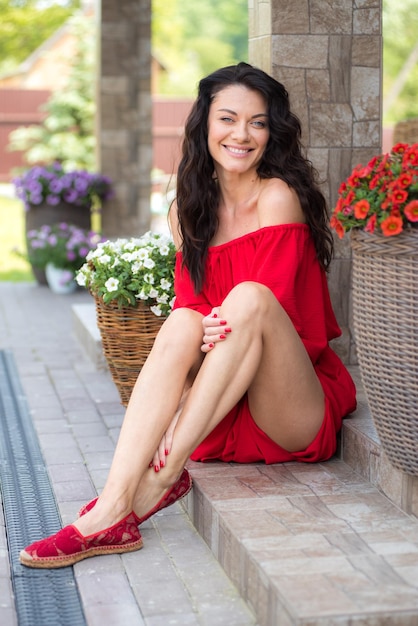 Femme en robe rouge dans le jardin