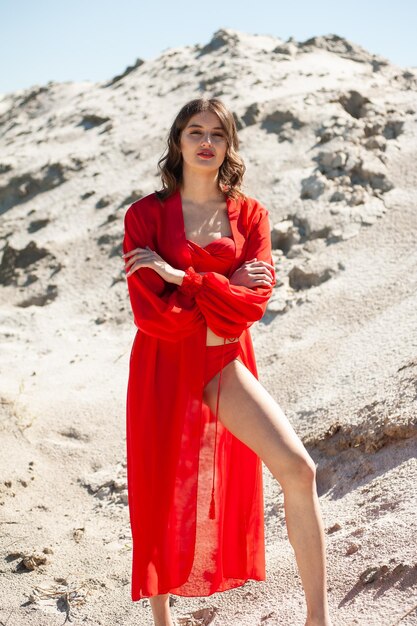 Femme en robe rouge debout sur la plage