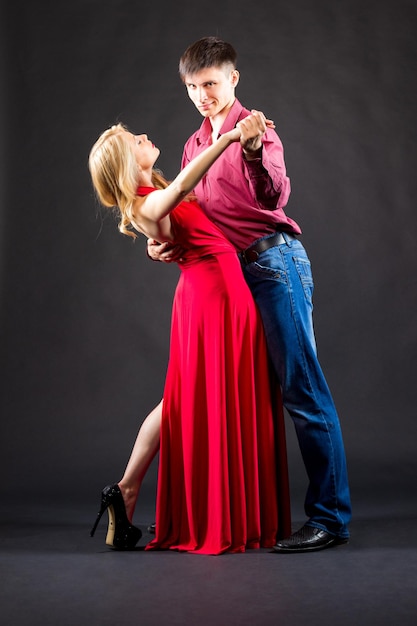 Femme en robe rouge et homme en costume posent