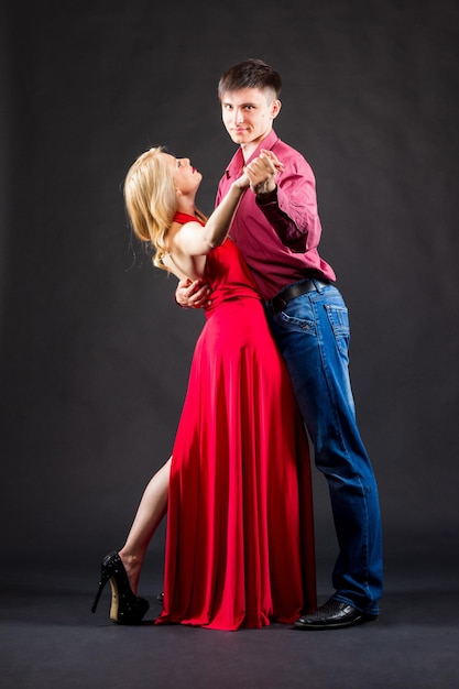 Femme en robe rouge et homme en costume posent