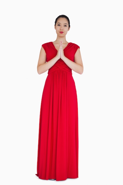 Femme en robe rouge avec les mains ensemble