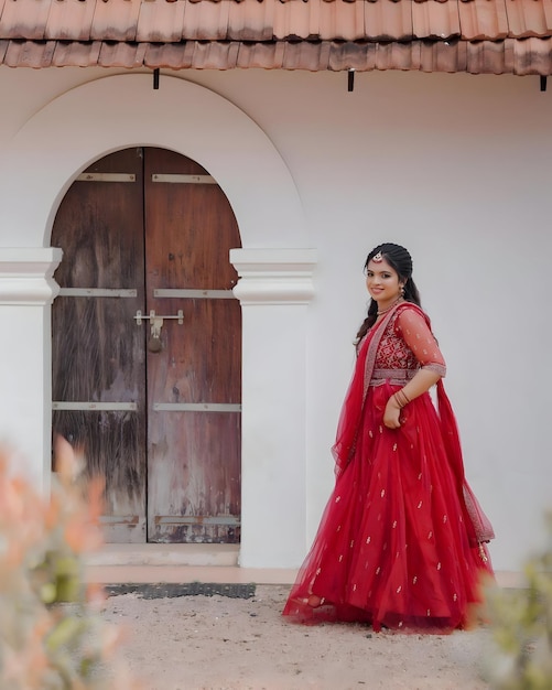 Photo une femme en robe rouge se tient devant une porte