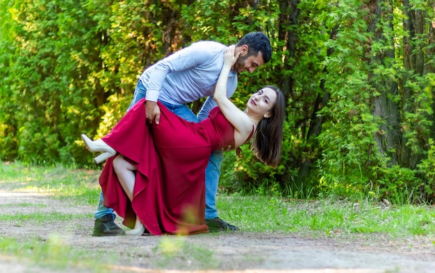 femme en robe rouge avec son petit ami dans le parc jeune couple dans le parc