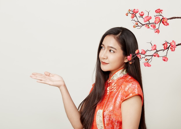 Femme en robe rouge traditionnelle chinoise avec des fleurs de prunier