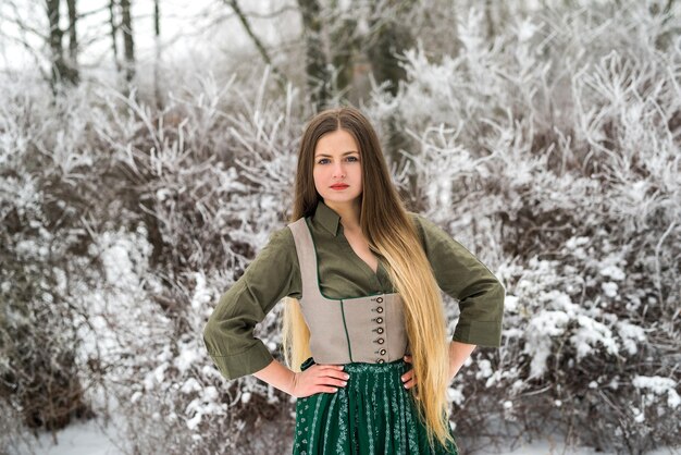 Femme en robe vintage posant dans le parc d'hiver