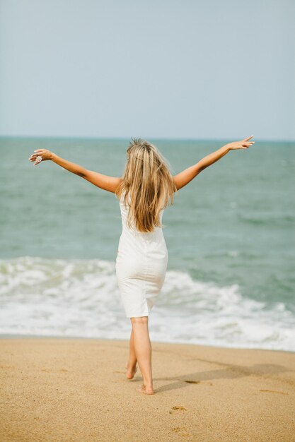 Femme romantique à pied sur la plage. Plage asiatique et vue sur la mer.