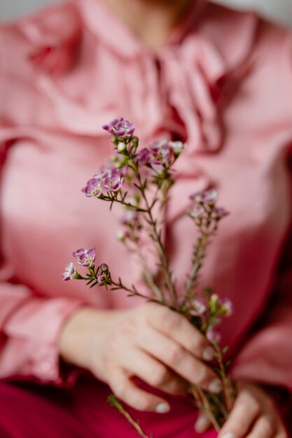 Femme en rose tenant des waxflowers