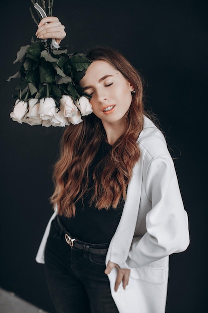 Femme avec des roses blanches sur fond noir