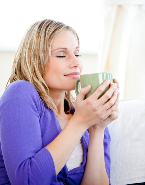 Femme rougeoyante tenant une tasse de café