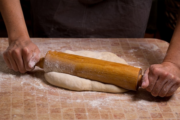 Une femme roule une pâte