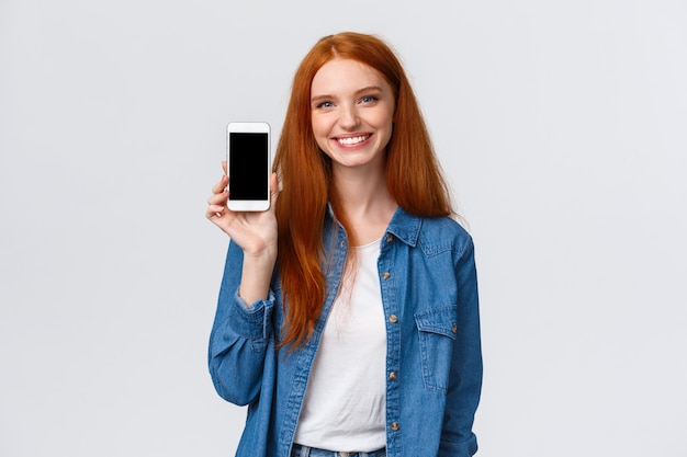 Femme rousse amicale joyeuse vérifiant l'application de l'eau, restez hydraté avec l'application pour smartphone