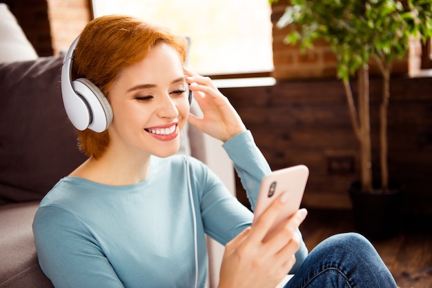 Femme rousse aux cheveux courts posant à l'intérieur dans le salon