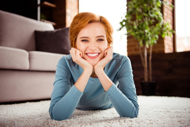 Femme rousse aux cheveux courts posant à l'intérieur dans le salon