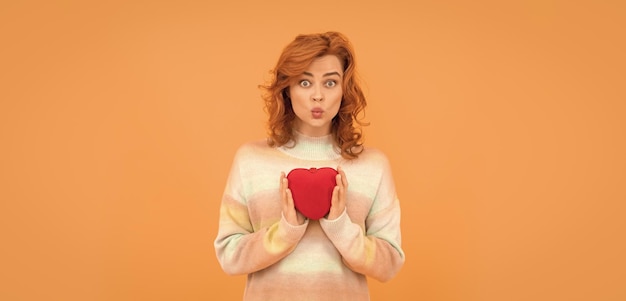 Femme rousse drôle avec coeur rouge sur fond orange valentines