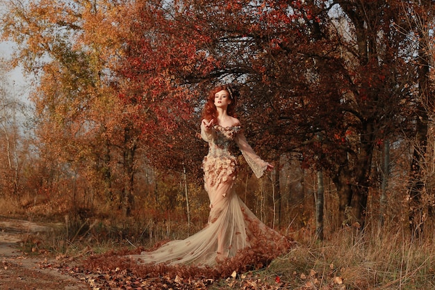 Femme rousse fantastique en forêt colorée d'automne