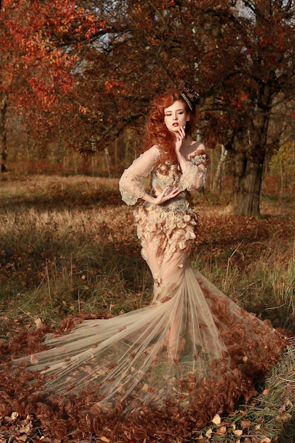 Femme rousse fantastique en forêt colorée d'automne