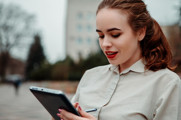 Femme rousse gingembre tenir tablet pc numérique et stylo