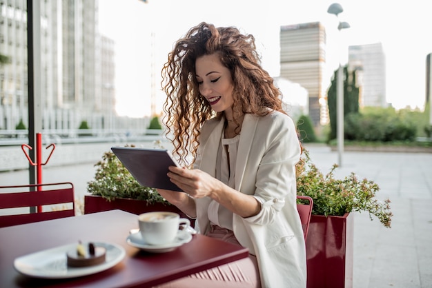 Femme rousse jeune entreprise sur la tablette