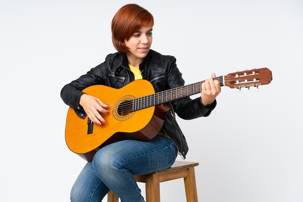 Femme rousse jouant de la guitare