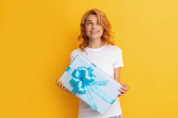 femme rousse joyeuse avec boîte présente sur fond jaune. bonne fête.