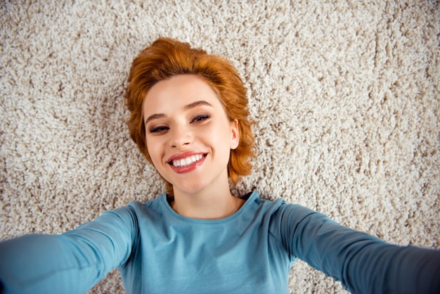 Femme rousse posant sur la moquette