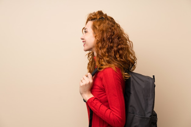 Femme rousse avec pull à col roulé avec sac à dos