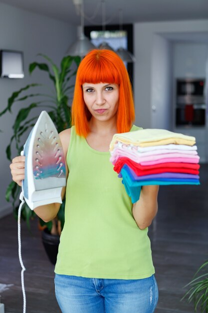 Femme rousse, repasser le linge à la maison