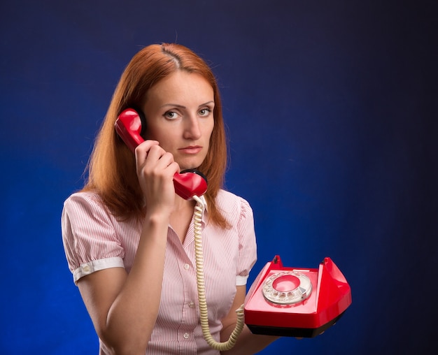 Femme rousse avec téléphone rouge