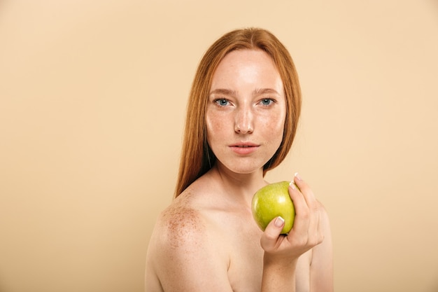 Femme rousse tenant la caméra à la recherche de pomme.