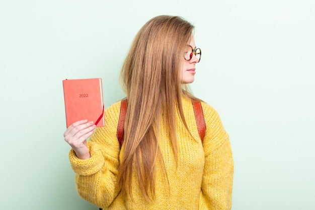 Femme rousse sur la vue de profil en pensant, en imaginant ou en rêvant concept de planificateur