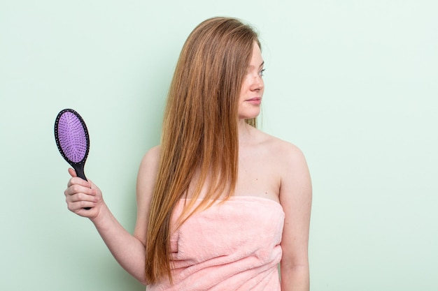 Femme rousse sur la vue de profil pensant imaginer ou rêvasser concept de peigne à cheveux