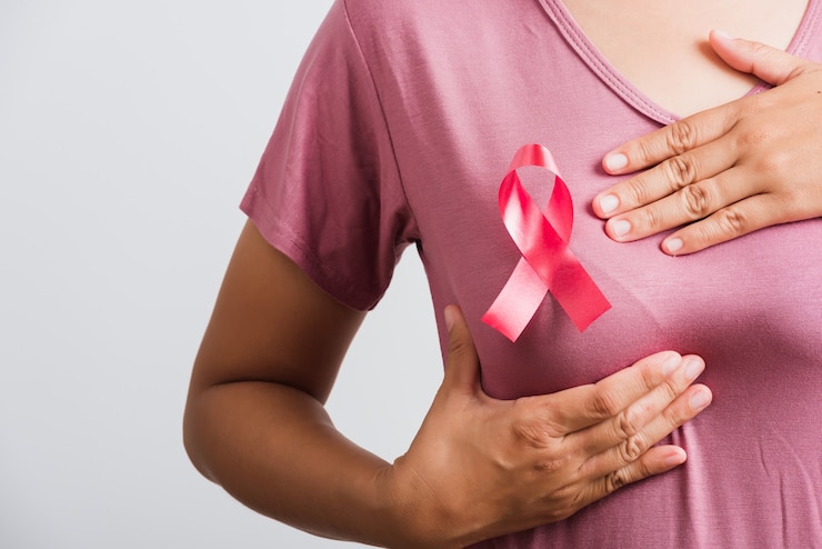 Photo une femme a un ruban de sensibilisation au cancer du sein rose sur la poitrine, elle tient le sein à la main