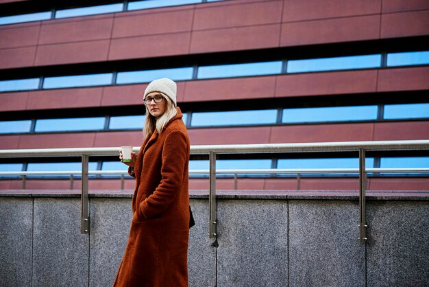 Femme à la rue de la ville avec une tasse de café