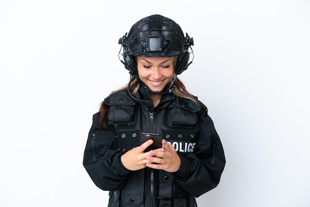 Femme russe SWAT isolée sur fond blanc envoyant un message avec le mobile