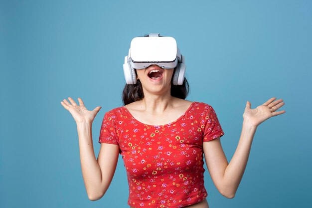 Femme s'amusant avec un casque VR sur fond bleu