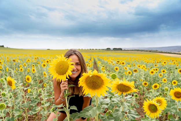 Une femme s'amuse parmi les tournesols.