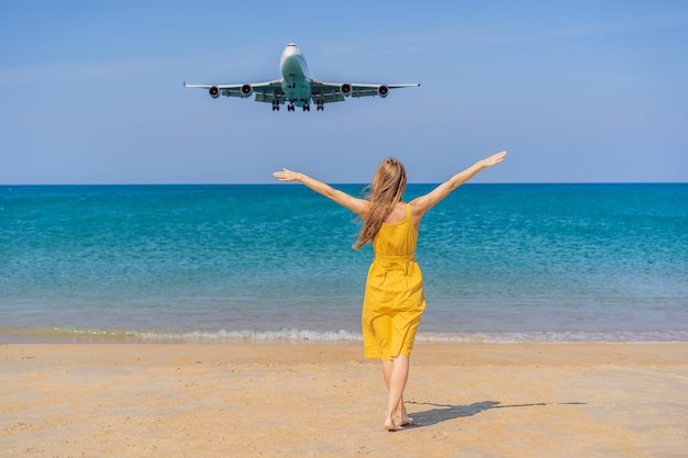 Femme s'amuser sur la plage en regardant les avions d'atterrissage voyageant sur un espace de texte de concept d'avion