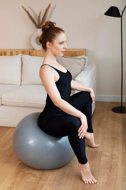 Photo femme s'entraînant sur un ballon de gymnastique