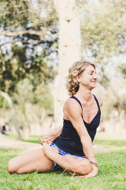 Photo une femme s'étendant sur un terrain herbeux dans un parc