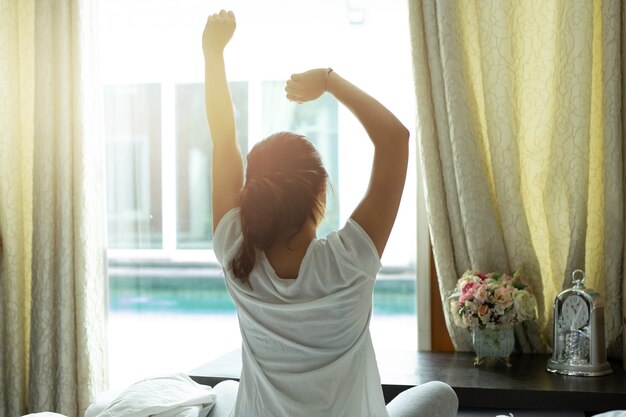 Femme s&#39;étirant après le réveil le matin