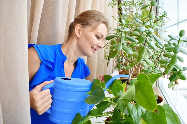 Femme s'occupant de fleurs en pot Fille arrosant des fleurs d'un arrosoir